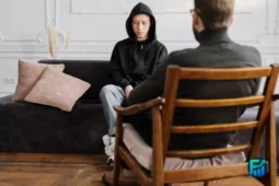 Young person sitting on a couch talking to a counsellor during a free therapy for youth session